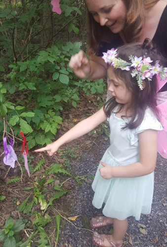 an adult fairy converses with a child fairy about the construction and materials involved in building a fairy house.