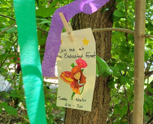 invitation info hanging in enchanted tree